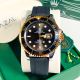 Black and gold Rolex watch, black dial, rubber strap